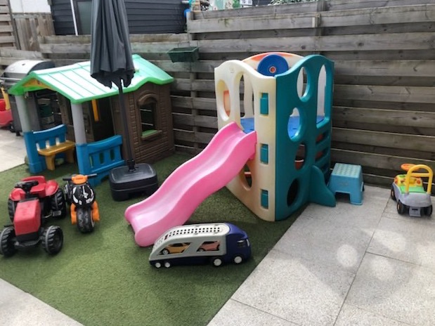 Kunstgras met glijbaan en speelhuis